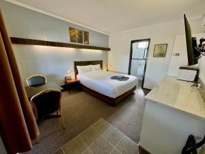 ein Hotelzimmer mit einem Bett und einem Schreibtisch in der Unterkunft Motel St Arnaud in Saint Arnaud