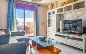ラ・カラ・デ・ミハスにあるBeautiful Apartment In La Cala De Mijas With Kitchenのリビングルーム(ガラステーブル、テレビ付)