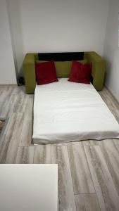 1 cama con 2 almohadas rojas en una habitación en Life Energy, en Voluntari