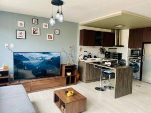 sala de estar con TV grande y cocina en Apartamento céntrico y panorámico en La Paz, en La Paz