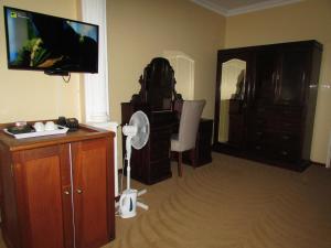 ein Wohnzimmer mit einem TV, einer Kommode und einem Spiegel in der Unterkunft Luxury Hotel in Bela Bela chateau in Bela-Bela