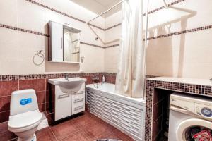 a bathroom with a toilet and a sink and a bath tub at Замок столицы in Astana