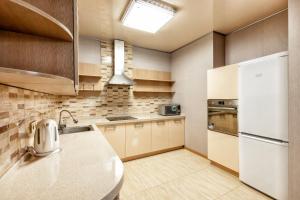 a kitchen with a sink and a refrigerator at Замок столицы in Astana