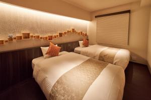 a hotel room with two beds and a window at SAKE Bar Hotel Asakusa in Tokyo