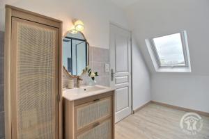 un bagno con lavandino e specchio di Le bon temps a Pleubian Altre 15 foto