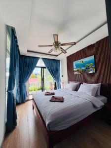 um quarto com uma cama e uma ventoinha de tecto em The White Palace Koh Sdach em Kaoh Sdach