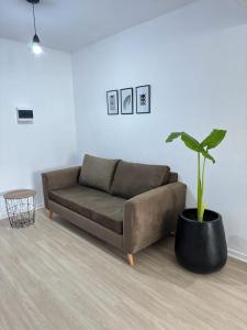 um sofá castanho numa sala de estar com um vaso de plantas em Departamento Pleno Centro de Córdoba Capital em Córdoba