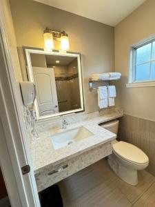 ein Badezimmer mit einem Waschbecken, einem WC und einem Spiegel in der Unterkunft Padre Oaks in Monterey
