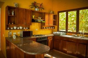 cocina con armarios de madera y encimera de granito en Villas Mamilú, entrada y salida 100 por ciento flexible en Santa Fe de Antioquia
