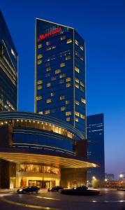 a marriott building with cars parked in front of it at Beijing Marriott Hotel Northeast in Beijing