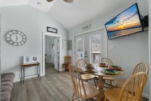 a dining room with a table and chairs and a clock at 232 W Pine Ave 2 Beds, 1 Bath in Wildwood