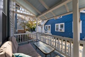 a patio with a couch and a table on a balcony at 232 W Pine Ave 4 Beds, 2 Baths in Wildwood