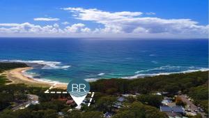 una vista aerea della spiaggia e del cartello stradale di Retro Vibes a Bateau Bay