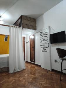 Zimmer mit einem Duschvorhang und einem TV an der Wand in der Unterkunft #Apartamento aconchegante no Flamengo - RIO in Rio de Janeiro