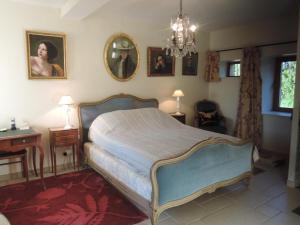 Schlafzimmer mit einem Bett und einem Kronleuchter in der Unterkunft Gîte Le Brethon, 7 pièces, 12 personnes - FR-1-489-499 in Le Brethon