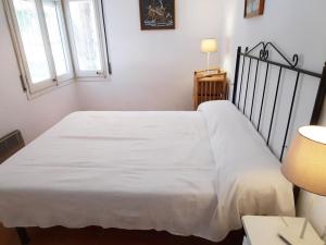 Cama blanca en habitación con 2 ventanas en Apartamento Llançà, 3 dormitorios, 8 personas - ES-170-69, en Llançà