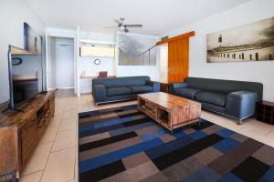 uma sala de estar com dois sofás e uma televisão em Best at Bright Point Absolute Waterfront Apartment em Nelly Bay