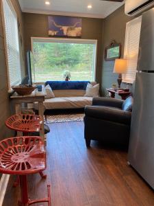 un soggiorno con divano e finestra di Tiny House Oasis Nature Escape Unit A a Nacogdoches