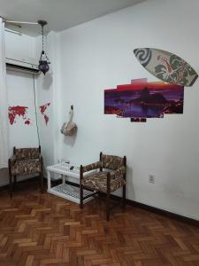 una habitación con 2 sillas y un cuadro en la pared en #Apartamento aconchegante no Flamengo - RIO en Río de Janeiro