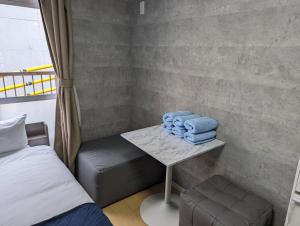 a room with a bed and a table with towels at Home cruise西小山 in Tokyo