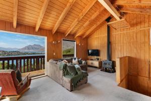 a living room with a couch and a fireplace and a balcony at The Lookout in Queenstown