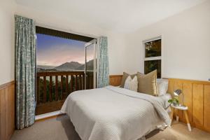 a bedroom with a bed and a large window at The Lookout in Queenstown