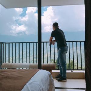 a man standing on a balcony looking out at the ocean at Roxana Sapa Hotel - by Bay Luxury in Sa Pa +8 photos