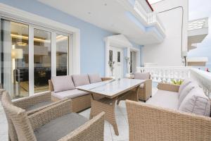 une salle à manger avec des chaises en osier et une table dans l'établissement Beach Blue Villa, à Corinthe