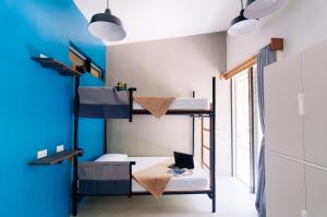a room with bunk beds and a laptop on a desk at Spin Designer Hostel - El Nido in El Nido