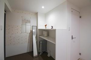 a small bathroom with white walls and a glass door at Forest Gardianホテル 京都御所西 in Kyoto