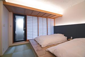 Rúm í herbergi á Forest Guardian Hotel 京都御所西