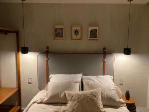 a bed with white sheets and pillows in a bedroom at Layoo, Tu Casa en Oaxca 105 in Oaxaca City