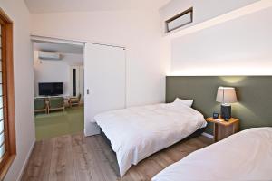 Rúm í herbergi á Forest Guardian Hotel 京都御所西
