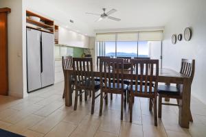 uma cozinha e sala de jantar com mesa e cadeiras em Best at Bright Point Absolute Waterfront Apartment em Nelly Bay