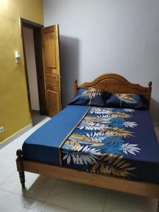 a bedroom with a bed with a blue comforter at Villa(Belle)près de Ouaga 2000. in Ouagadougou