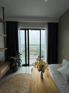 a living room with a couch and a table with flowers on it at Moon homestay, apartment Hue in Hue