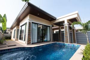 a house with a swimming pool in front of it at Aonang Oscar Pool Villas in Ao Nang Beach