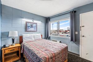 a bedroom with a bed and a window at Broadway Inn in Council Bluffs