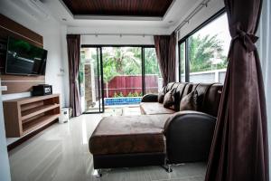 a living room with a couch and a large window at Aonang Oscar Pool Villas in Ao Nang Beach