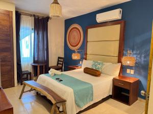 a bedroom with a large bed with a blue wall at Suites Valentina in Puerto Morelos