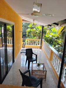 a room with chairs and a table and a balcony at Primavera Holiday Homes in Candolim