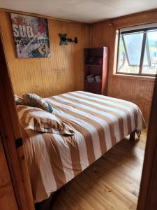 a bedroom with a bed in a room with a window at Ruta Austral - Coyhaique in Coihaique