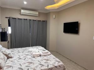 1 dormitorio con 1 cama con toallas en Killari suite en Tinogasta