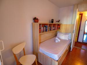 Habitación pequeña con cama con estante para libros en Aquamarine Terrace Apartment by Hello Homes Sitges, en Sitges