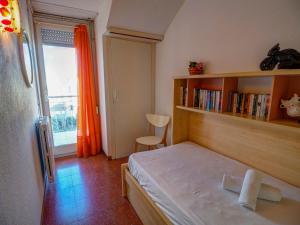Dormitorio pequeño con cama y estante de libros en Aquamarine Terrace Apartment by Hello Homes Sitges, en Sitges