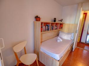 Habitación pequeña con cama y estante para libros en Aquamarine Terrace Apartment by Hello Homes Sitges, en Sitges