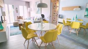 uma sala de estar com uma mesa e cadeiras amarelas em Beachstyle Penthouse by Hello Homes Sitges em Sitges