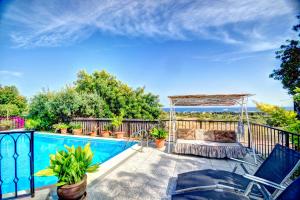 a swimming pool with a pergola next to a fence and a swimming pool at Can Ferran by Hello Homes Sitges in Sitges