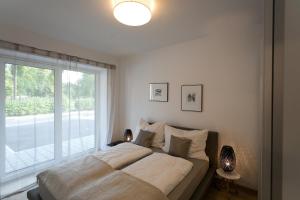 a bedroom with a large bed and a window at Parksuites Apartments Graz in Graz