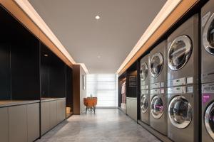 una lavanderia con 4 lavatrici e asciugatrici di Hefei Huiyan Anhui Center Intercity Hotel a Hefei Altre 6 foto